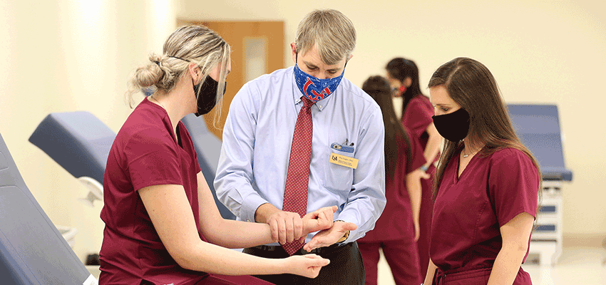 Image of Physician Assistant Studies instructor in lab with students.