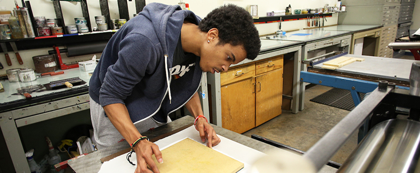 Art student working in printmaking studio.