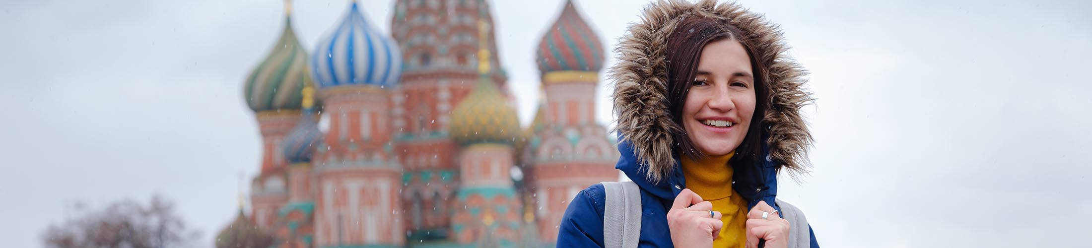 Woman in jacket in front of castle.