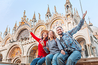 Three students smiling in front of Italian castle 