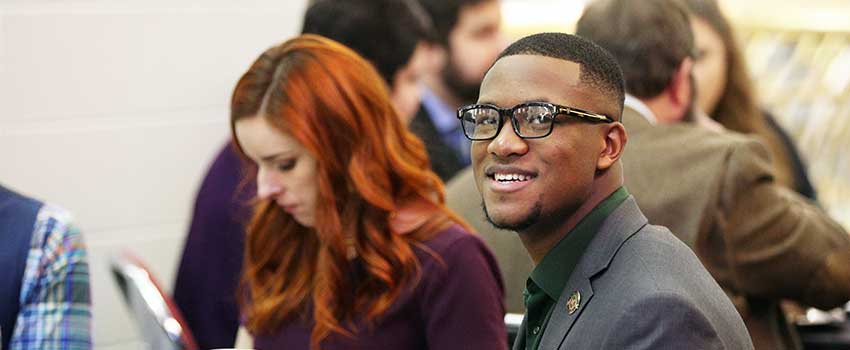 Student smiling in suit.