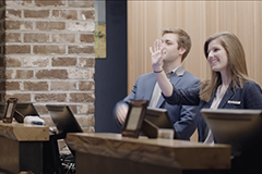 Male and female behind desk at hotel