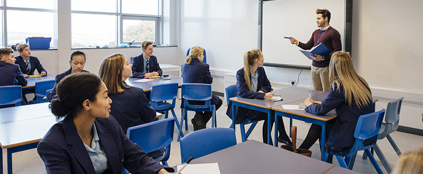 Teacher in front of class teaching to class.