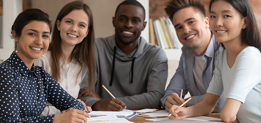 A group of students writing at a table.