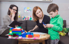 FTwo females workng with child with building blocks.