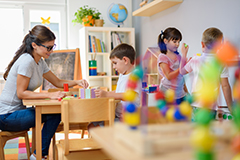 Teacher working with kids with building blocks