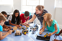 Teacher working with class building vehicles.