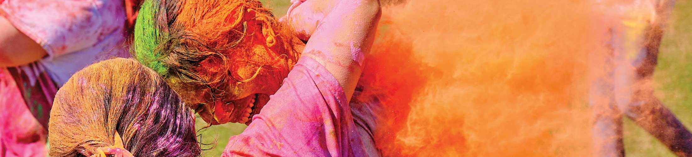 Students covered in color during Holi event.