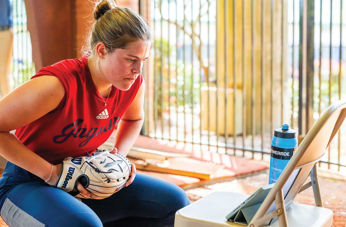 IN BETWEEN PITCHES, KOOPER BARNES checks her stats measured by the Rapsodo.