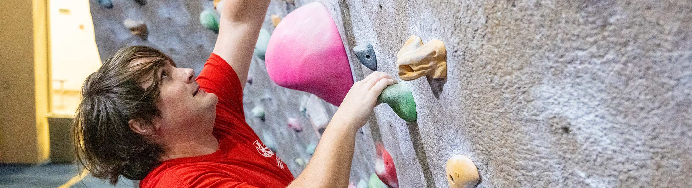 Student climbing rockwall.