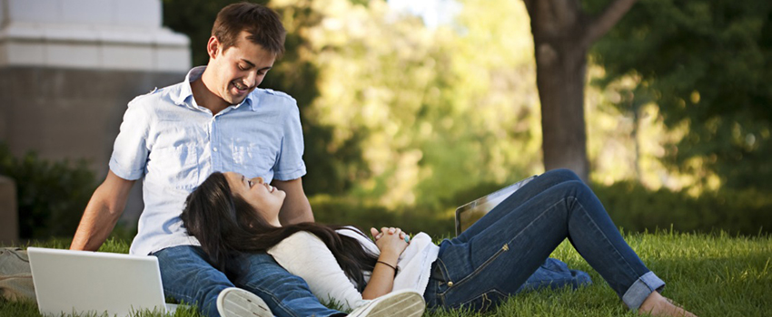 Man and woman sitting outside in grass