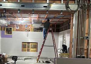 Man on ladder working on MRI room.