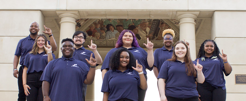 2022-2023 Jaguar Productions Board standing in front of Moulton Tower with J's up.