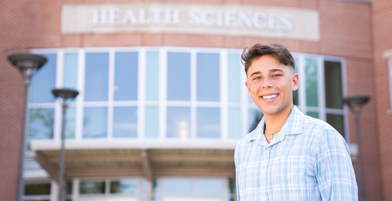 Nicholas Cooper, the 2025 University of South Alabama Board of Trustees Scholar, in front of the Health Sciences Building.