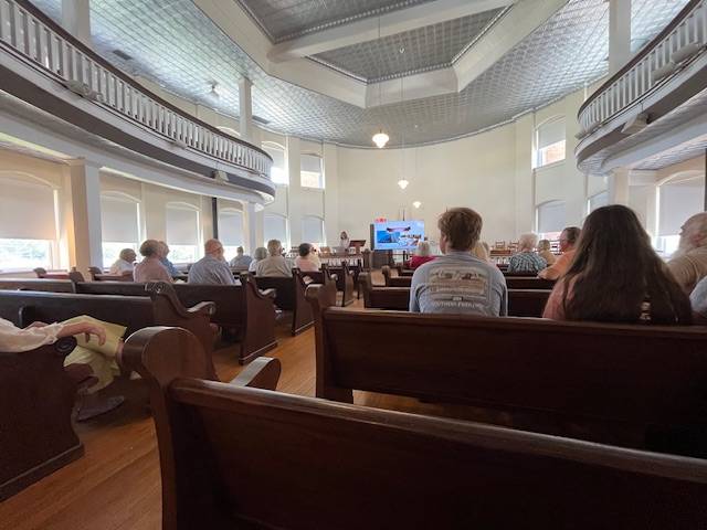 Audience members sit in the courthouse building 