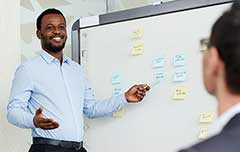 Male instructor pointing to notes on a whiteboard.